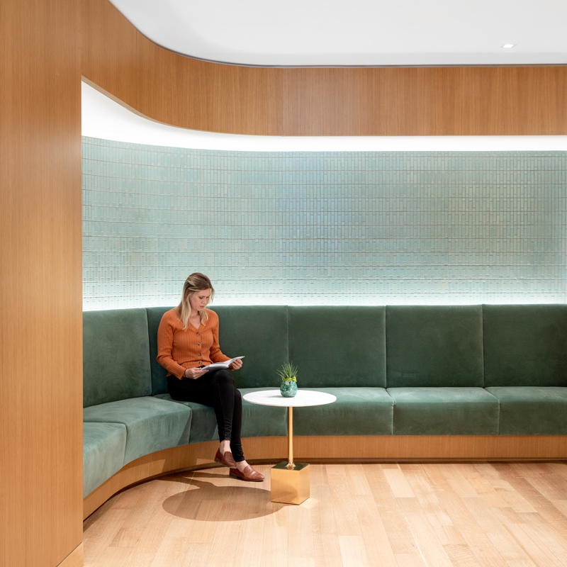 Curved LED lighting frames the green lounge room