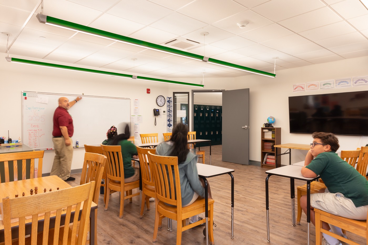 BOOM, in the school's official green, sends light up to the ceiling and down to the desks.