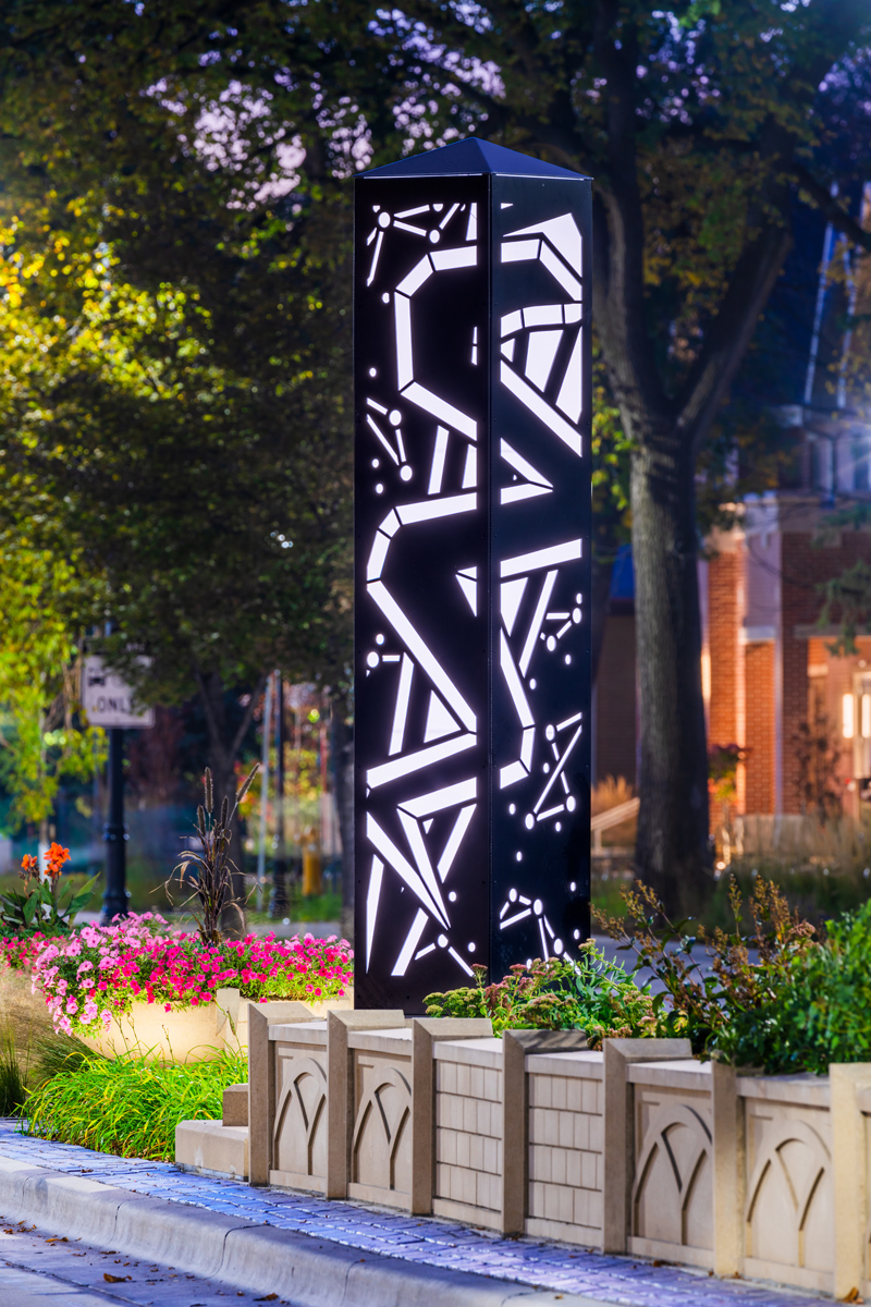 Illuminated LED tower sits beautifully in blooming landscape garden